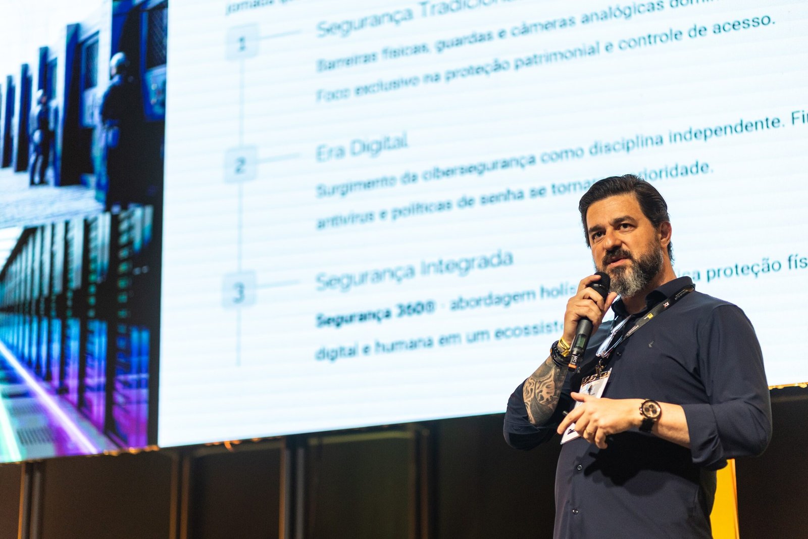 Leo Soares com microfone, apresentando Segurança 360 em evento